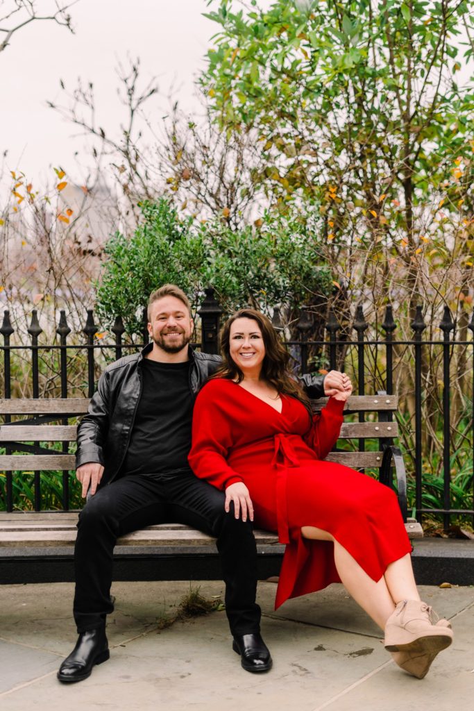 a couple sitting on a bench together while they are smiling. 