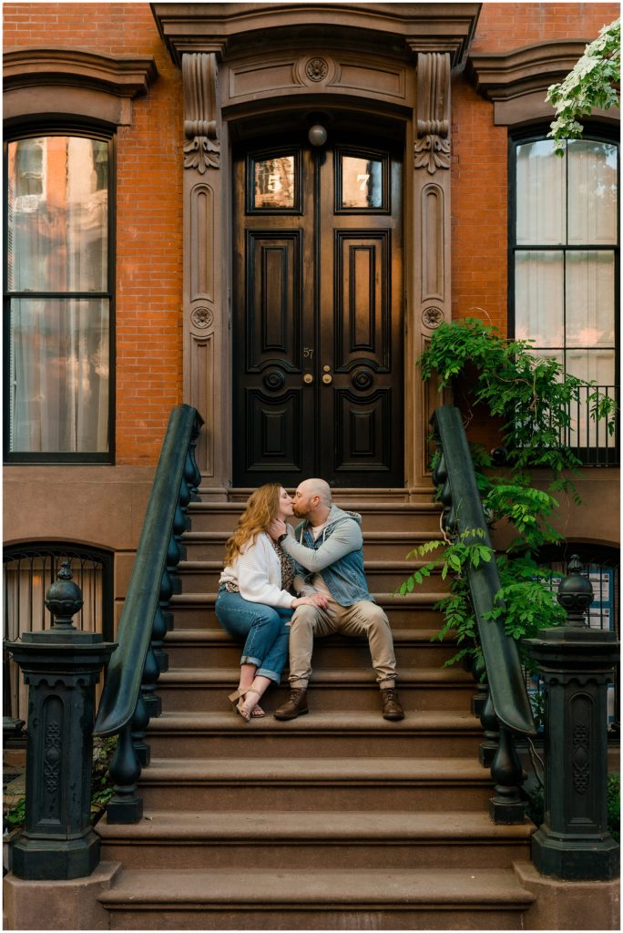 a couple sitting together on a stoop kissing in the middle