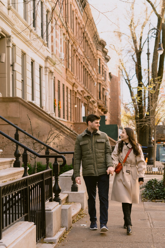 a couple walking on a side walk in the upper west side neighborhood of new york city