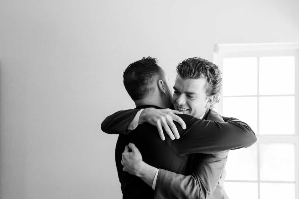 two men hugging and smiling