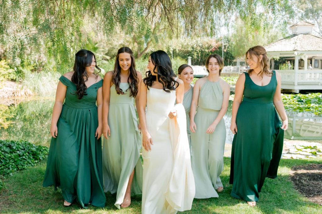 a bride walking aside her bridesmaids while everyone is looking at each other. 