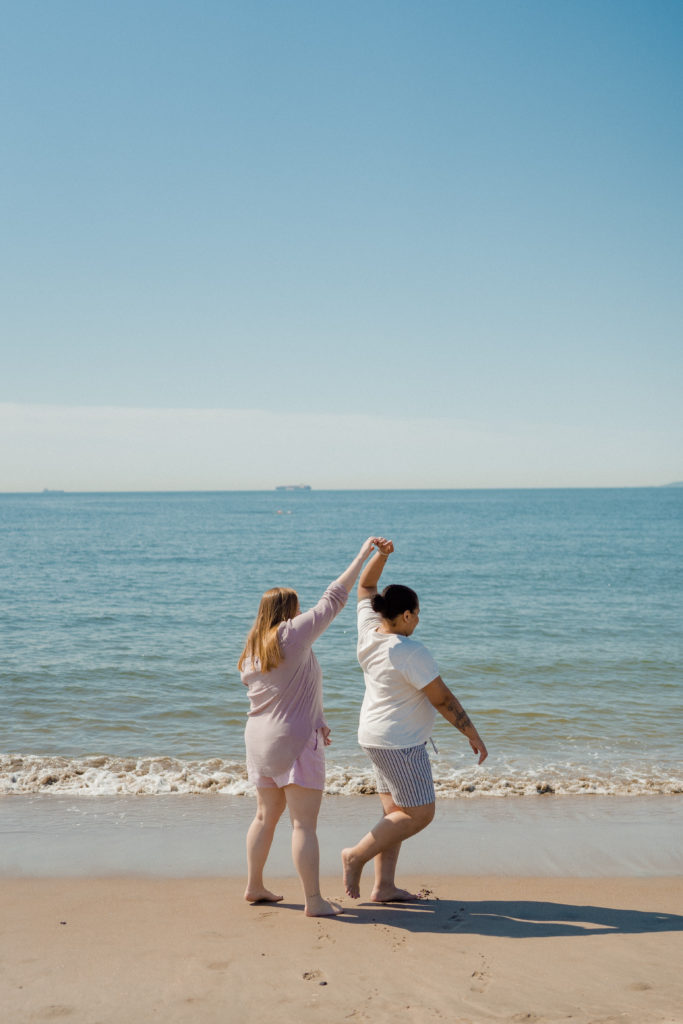 a couple dancing in front of the ocean