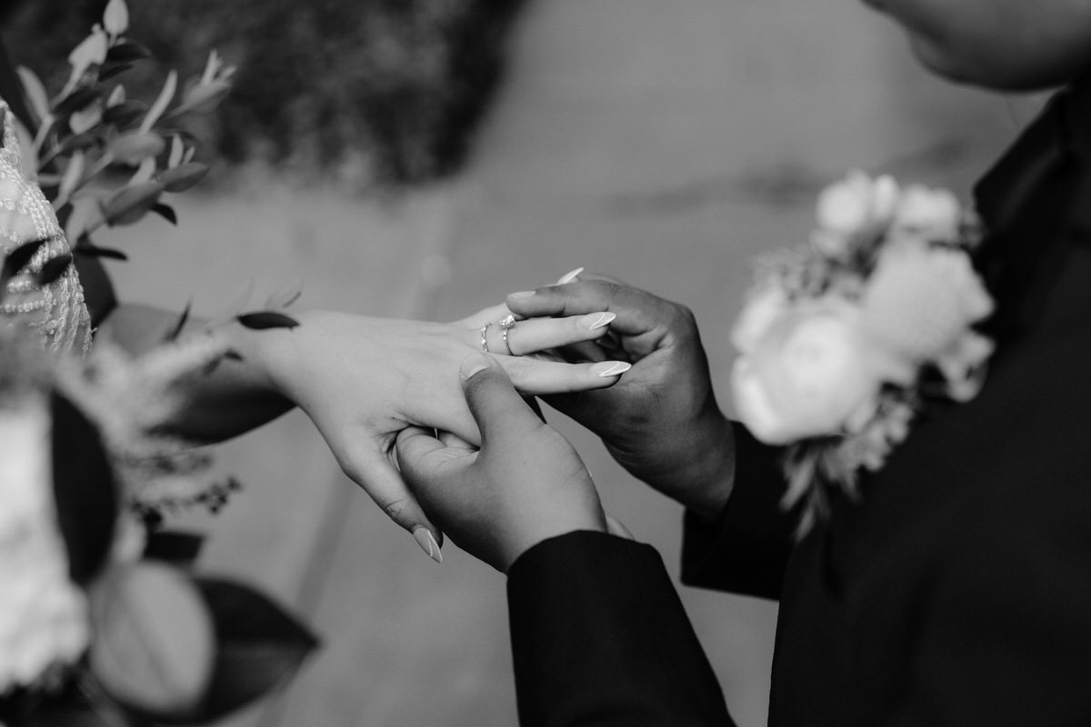A groom slipping a ring on a brides finger during their 501 Union wedding.