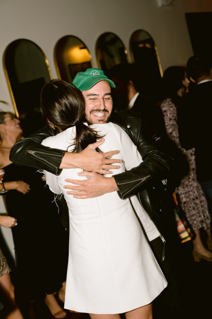 A person hugging another person at a party. 
