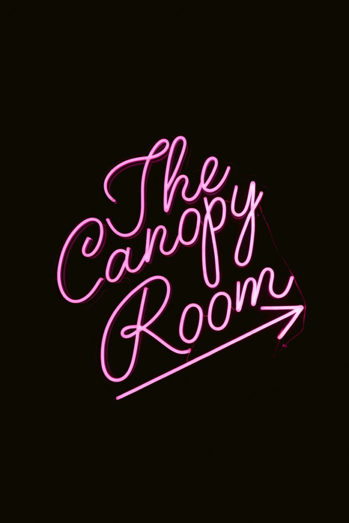 A neon sign that reads "The Canopy Room"

