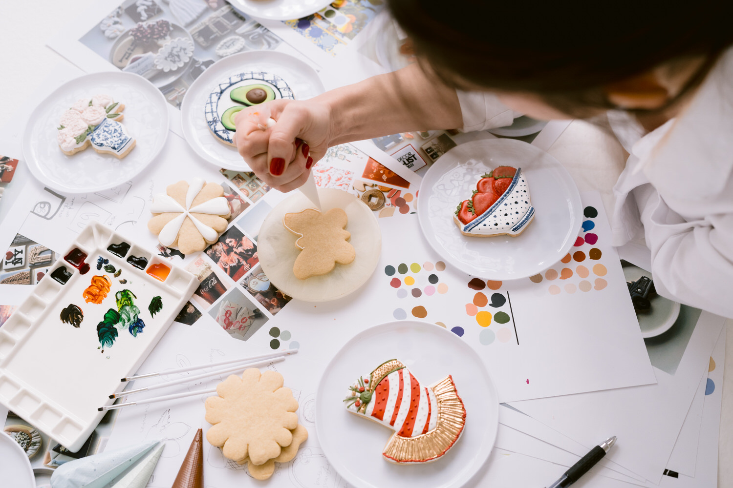 Person creating art on cookies during a brand photoshoot