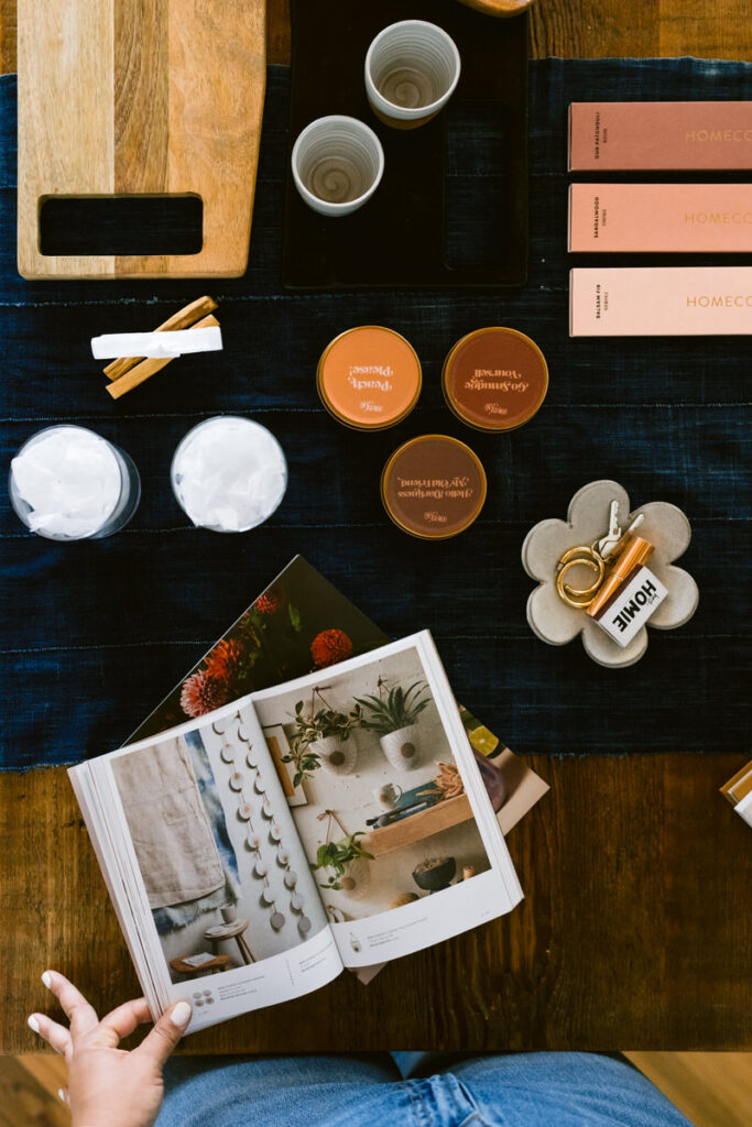 a book on a table next to candles, incense, and other small items 
