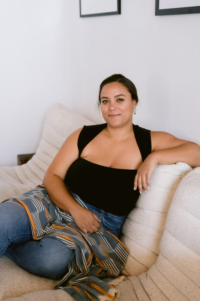 A person smiling and lounging on a couch 
