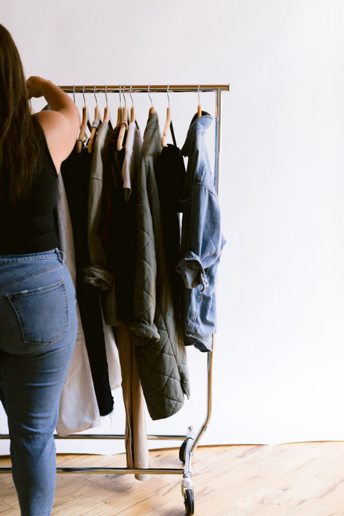 A person sifting through clothes on a rack 
