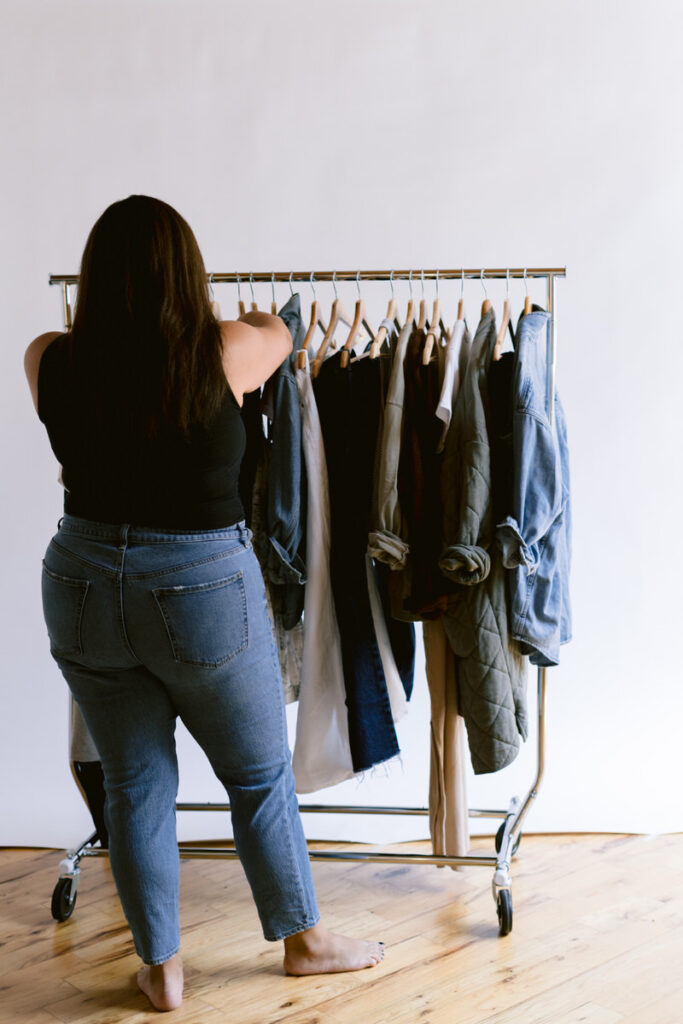 A person sorting through clothes on a rack 
