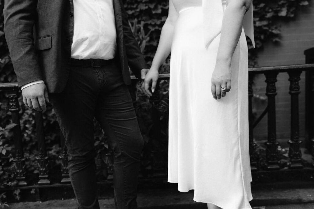 Black and white close up of a couple holding hands 