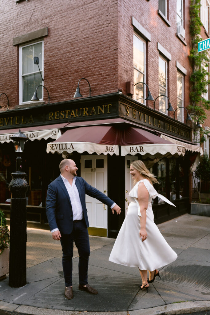 A couple dancing on a city sidewalk 