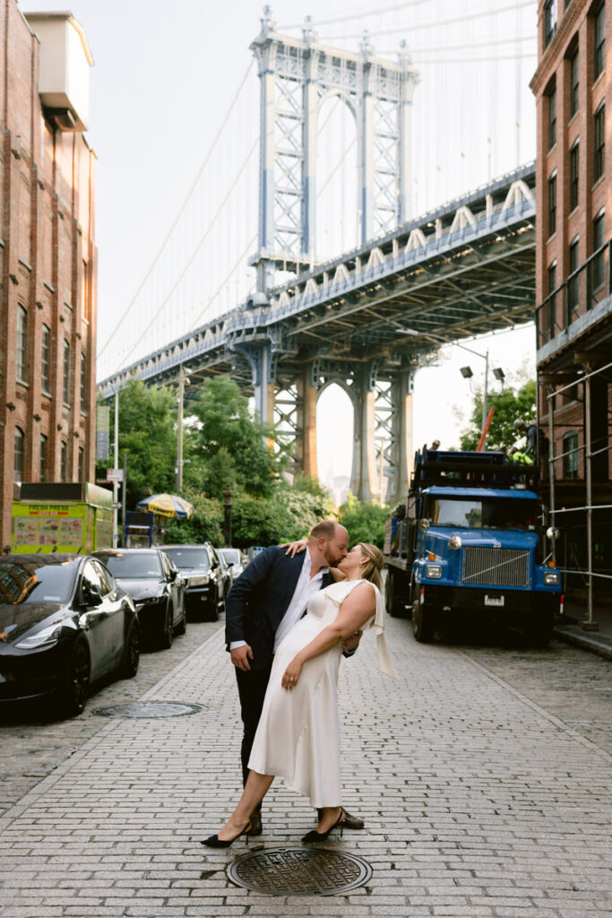 A couple kissing on a side street in a city 